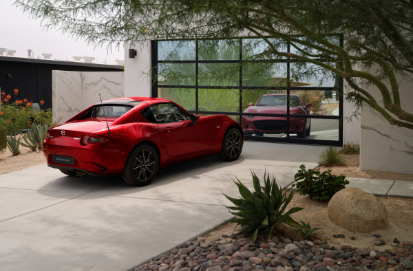 Red Mazda MX-5 RF driving on a curved road.